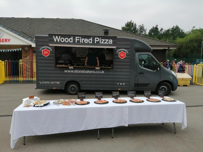 Central photo of buffet table full of pizza with the stonebakers van in the background